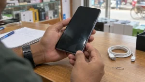 দোকানে হাতে ধরে ব্যবহৃত স্মার্টফোন পরীক্ষা